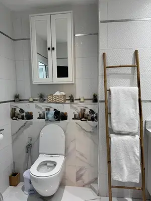 a white bathroom with a toilet and a mirror at Appartement centre Marrakech gueliz - Cool & Cozy Apartment for a Family Stay in the Heart of the City in Marrakech