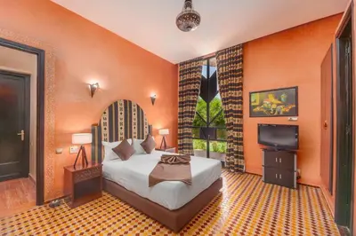 a bedroom with a bed and a flat screen tv at Domaine Marradise in Marrakech