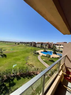 a balcony with a view of a golf course at Marrakech Prestigia 3 chambres in Marrakech