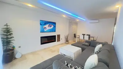 a living room with a couch and a fireplace at mini-villa situee dans une residence Prestigia à Marrakech, avec une vue sur la piscine et le golf une securite 24h sur 24 et une proximite ideale de l aeroport 5 minutes C est une offre parfaite pour des vacances in Marrakech