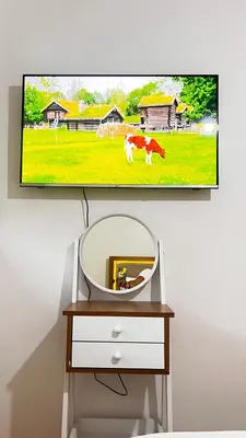 a television hanging on a wall with a cow on a field at mini-villa situee dans une residence Prestigia à Marrakech, avec une vue sur la piscine et le golf une securite 24h sur 24 et une proximite ideale de l aeroport 5 minutes C est une offre parfaite pour des vacances in Marrakech