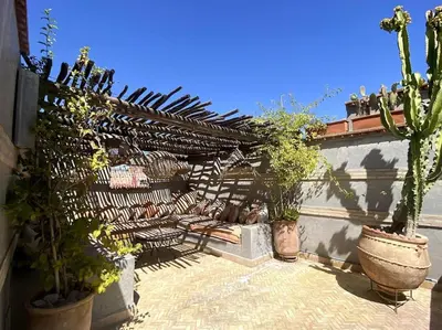 a patio with a fence and a bunch of plants at Riad Kismet Marrakech in Marrakech