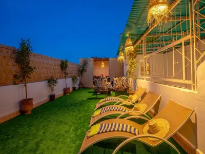 a row of chaise lounges and chairs on a balcony at Pretty Apartment in the Medina 2 in Marrakech