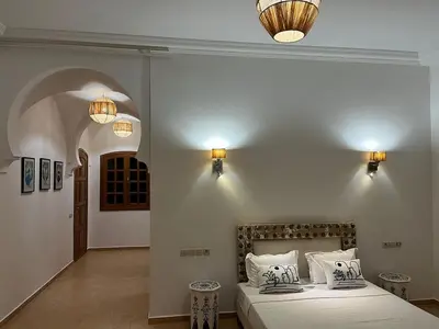 a bedroom with a bed and two lights on the wall at Villa Keshmere in Marrakech