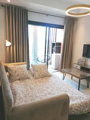 a bedroom with a large bed and a table at Cosy appartement au Domaine de Noria in Marrakech