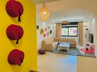 a living room with a yellow wall and a couch at Le Gueliz Centeral cosy Suite in Marrakech