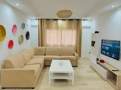 a living room with a couch and a tv at Le Gueliz Centeral cosy Suite in Marrakech