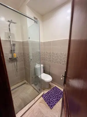 a bathroom with a toilet and a glass shower door at Superbe appartement au porte de gueliz in Marrakech