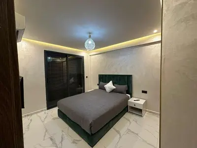 a bedroom with a bed and a large window at Résidence Joudad Guéliz in Marrakech