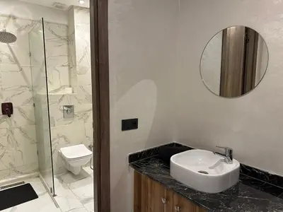 a bathroom with a sink and a toilet and a mirror at Résidence Joudad Guéliz in Marrakech