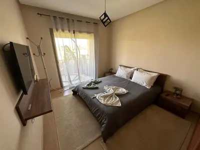 a bedroom with a bed with two plates on it at Appartement avec Piscine Prestigia Agate Marrakech in Marrakech