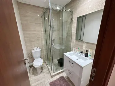 a bathroom with a shower and a toilet and a sink at Appartement avec Piscine Prestigia Agate Marrakech in Marrakech