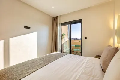 a bedroom with a bed and a large window at RA 14 Calme et Cosy Netflix, Wifi et parking gratuits in Marrakech