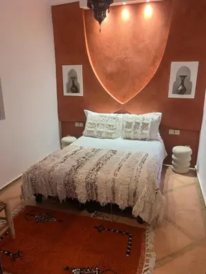 a bedroom with a bed with a large mirror on the wall at Riad Le Saaliya in Marrakech