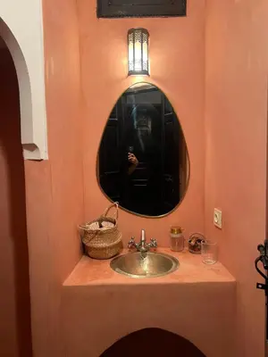 a bathroom sink with a mirror and a person taking a picture at Riad Le Saaliya in Marrakech