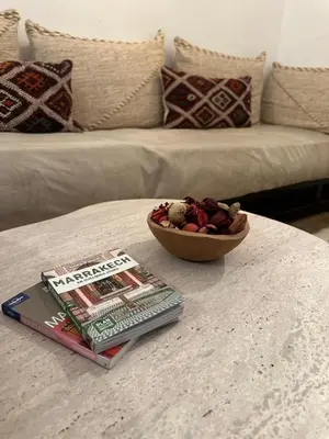 a table with a book and a bowl of food on it at Riad Le Saaliya in Marrakech