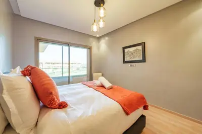 a bedroom with a bed with an orange blanket on it at Relax Front Of Golf-Atlas in Marrakech
