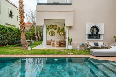 a house with a swimming pool in a yard at Villa Zeitoune - 8 pers - Piscine - Marrakech in Marrakech