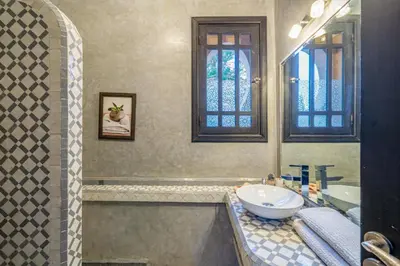 a bathroom with a tub and a sink and two windows at Villa Zeitoune - 8 pers - Piscine - Marrakech in Marrakech