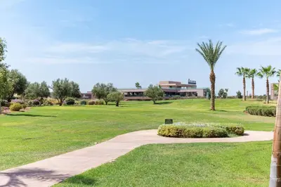 a walkway through a park with palm trees and a building at Relax front of Golf-Pool-Topaze in Marrakech