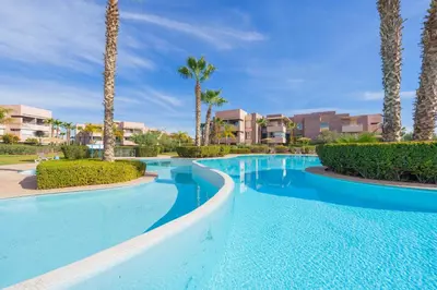 a swimming pool at a resort with palm trees at Chic Escape Sunny Terrace Pool Cenima Bed Fiber Wi-Fi in Marrakech
