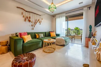 a living room with a green couch and a table at Chic Escape Sunny Terrace Pool Cenima Bed Fiber Wi-Fi in Marrakech