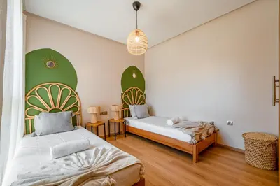two beds in a room with green and white walls at Chic Escape Sunny Terrace Pool Cenima Bed Fiber Wi-Fi in Marrakech