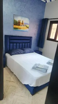 a bedroom with a large bed with a painting on the wall at Riad marrakech boujloud in Marrakech