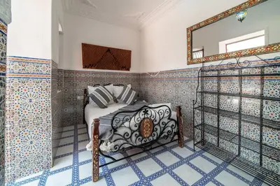 a bedroom with a bed and a mirror on the wall at Riad Khadoj-Marrakech-Traditional in Marrakech