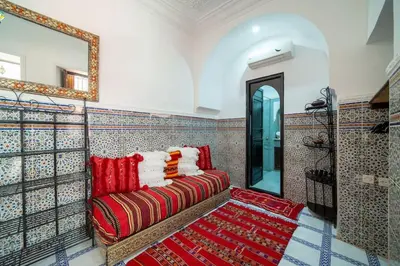 a living room with a couch and a mirror at Riad Khadoj-Marrakech-Traditional in Marrakech