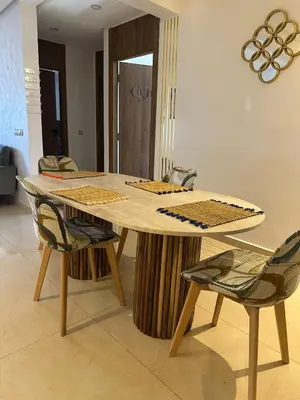 a wooden table with two chairs in a room at Appartement pour famille ou couple à Marrakech in Marrakech