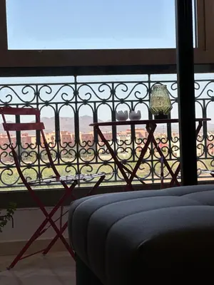 a table and chair on a balcony with a view at Appartement Zazat in Marrakech