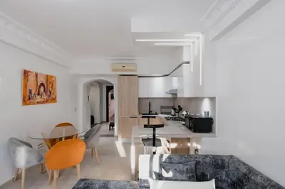a kitchen and living room with a table and chairs at Gueliz Luxury Apt with Pool Self Check In 24 7 Security in Marrakech