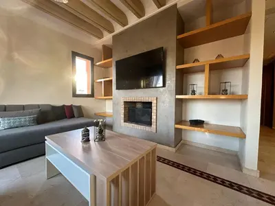a living room with a couch and a fireplace at Résidence Dar Damana Palmeraie Marrakech in Marrakech
