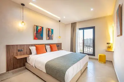 a bedroom with a large bed with orange pillows at R35 Paisible et tout confort : Netflix+parking+Wifi gratuit in Marrakech
