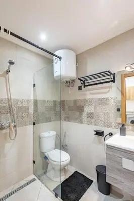 a bathroom with a toilet and a glass shower at R35 Paisible et tout confort : Netflix+parking+Wifi gratuit in Marrakech