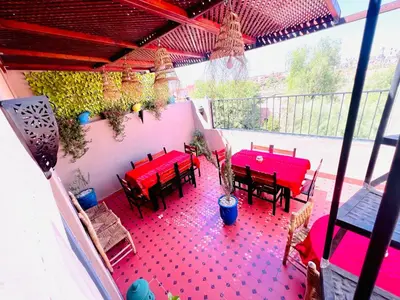 a patio with red tables and chairs on a balcony at Al Bahja family in Marrakech