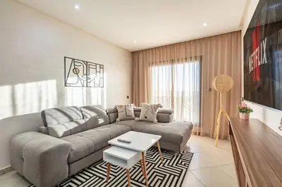 a living room with a couch and a table at RA26 Elegant&Chaleureux Netflix et parking gratuit in Marrakech
