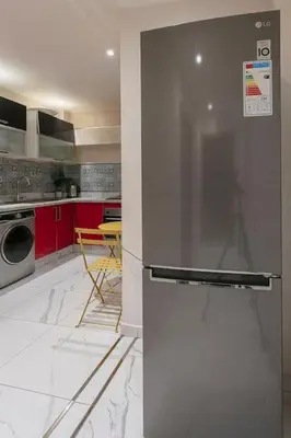 a kitchen with red cabinets and a stainless steel refrigerator at Red City Rendezvous – Downtown in Marrakech