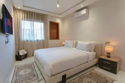 a white bedroom with a large bed and a window at Red City Rendezvous – Downtown in Marrakech