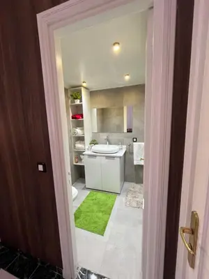 a bathroom with a white sink and a green rug at Tigami in Marrakech