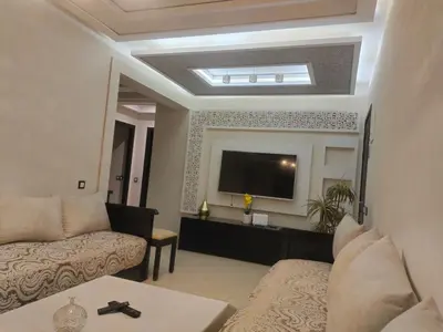 a living room with a couch and a flat screen tv at Appartement Bayt Atik in Marrakech