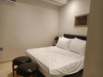 a bedroom with a white bed with two stools at Appartement Bayt Atik in Marrakech