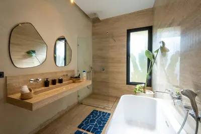 a bathroom with a tub and a sink and a mirror at Villa Hicham Golf Marrakech in Marrakech