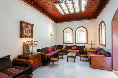 a living room with couches and tables and windows at Villa Dar Sultan - Marrakech in Marrakech
