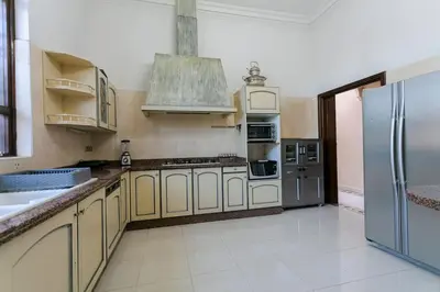 a large kitchen with stainless steel appliances and a refrigerator at Villa Dar Sultan - Marrakech in Marrakech