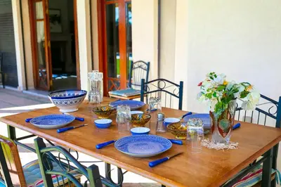 a wooden table with blue plates and a vase of flowers at Villa Dar Sultan - Marrakech in Marrakech