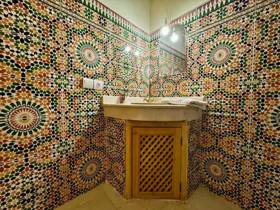 a bathroom with a sink and a mosaic wall at Riad Flottement Des Songes in Marrakech
