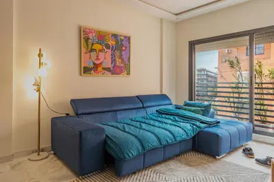 a blue couch in a room with a window at Beau Studio au hub de Gueliz in Marrakech