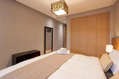 a bedroom with a large bed with a towel on it at Poolside Apartment's-Green View in Marrakech